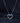 Сребърно колие със сърце от блестящи мойсанити върху тъмен фон